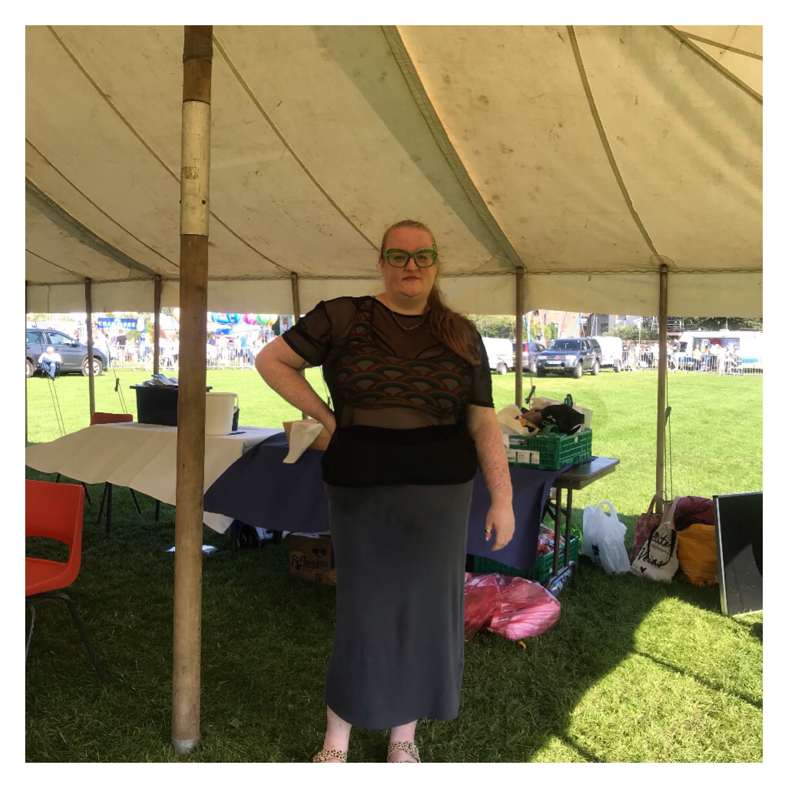 Plus size woman in tent wearing maxi skirt & rainbow crop top