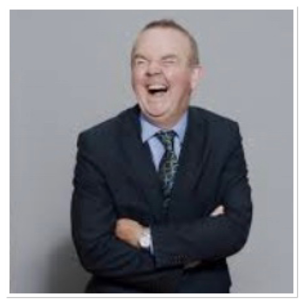 Laughing man in a suit with arms crossed 